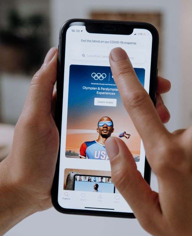Hand holding a phone with a search bar on screen